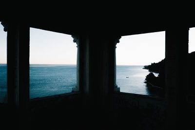 Scenic view of sea against clear sky seen through window