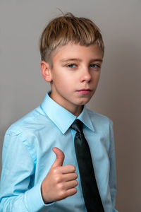 Portrait of young man standing against wall