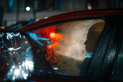 Close-up of man in car in the city at night