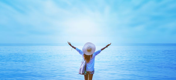 Rear view of woman jumping in sea