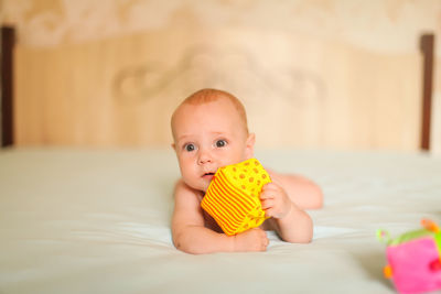 Cute baby boy lying on bed at home