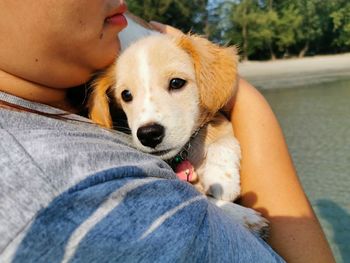 Midsection of woman hugging dog outdoors