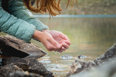 Close up, hands in the water from a glacial stream from the spring thaw. clean refreshing drinking