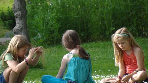 Children sitting on a grass in a park