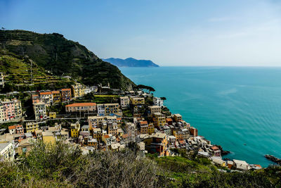 Aerial view of townscape by sea against sky