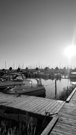 Boats moored at harbor against clear sky