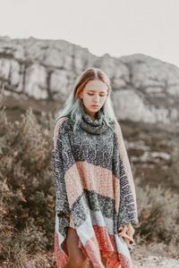 Young woman with warm clothing standing outdoors