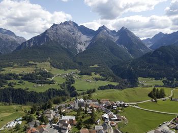 Scenic view of townscape and mountains against sky