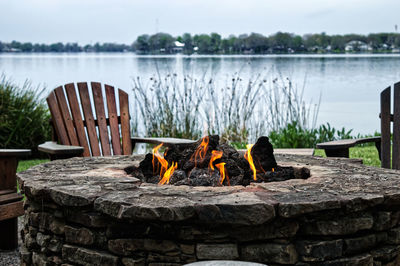 Firepit in front of lake against sky