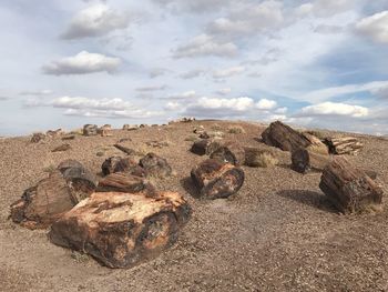 Stack of rocks on field against sky