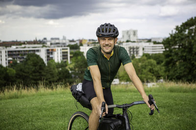 Portrait of man riding bicycle on grass