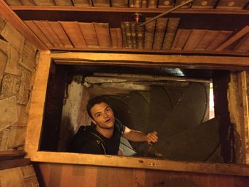 Portrait of young man climbing steps in old house