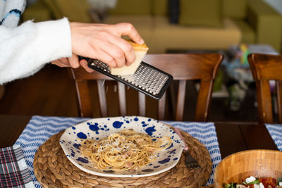 Midsection of person holding food on table