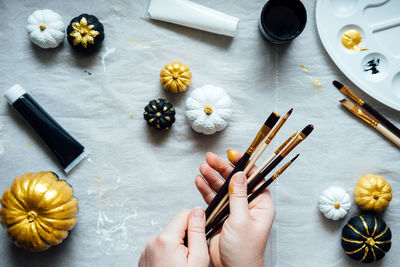 Painting black and gold pumpkins with female hands. creative pumpkin painting ideas for halloween