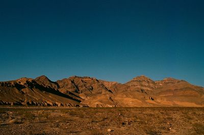 Scenic view of landscape and mountains against clear blue sky