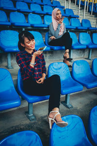 Full length of young couple sitting on chair