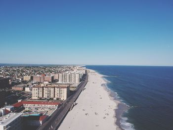 Scenic view of beach against clear blue sky