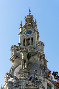 Low angle view of statue against building against clear sky