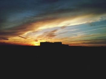 Silhouette of built structure against dramatic sky