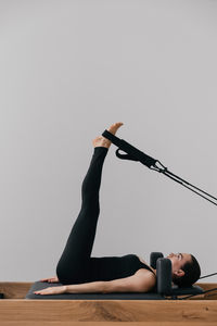 Low section of woman exercising against clear sky