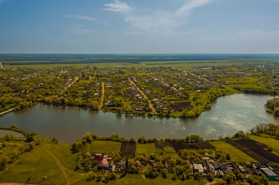 High angle view of city by sea against sky