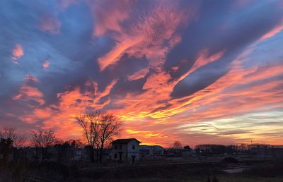 Scenic view of dramatic sky over field during sunset