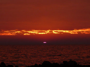 Scenic view of sea against orange sky