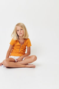 Cute girl sitting over white background