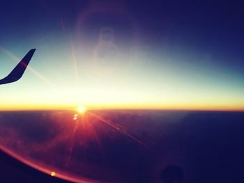 Close-up of airplane wing against sky during sunset