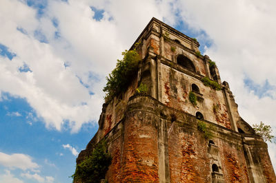 Low angle view of old building against cloudy sky