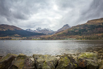 Calm lake against rocky mountain range