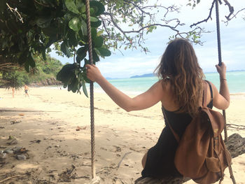 Rear view of woman standing on beach