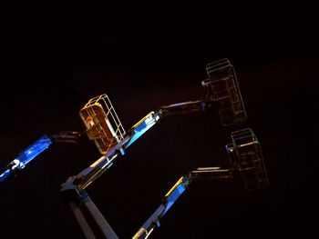 Low angle view of illuminated lighting equipment against sky at night