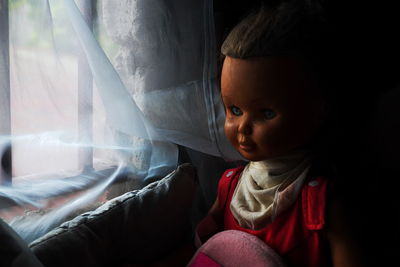 Close-up of doll by window at home