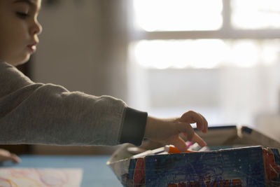 Side view of boy playing with toys on table