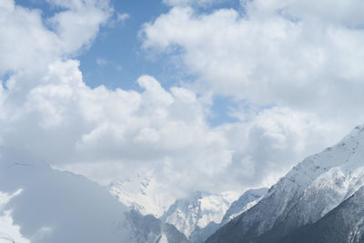 Low angle view of snowcapped mountains against sky