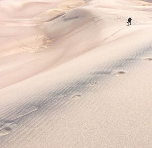 High angle view of silhouette man walking at desert