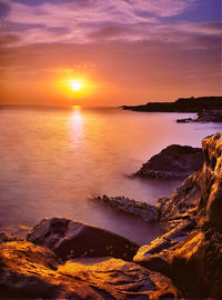 Scenic view of sea against romantic sky at sunset