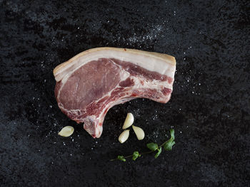 Directly above shot of raw meat with ingredients on kitchen counter