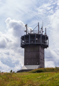 Low angle view of traditional windmill on field against sky