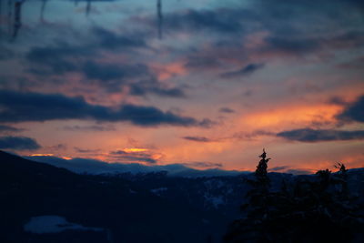 Scenic view of silhouette mountains against orange sky