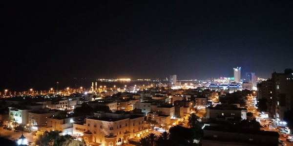 High angle view of illuminated buildings against sky at night
