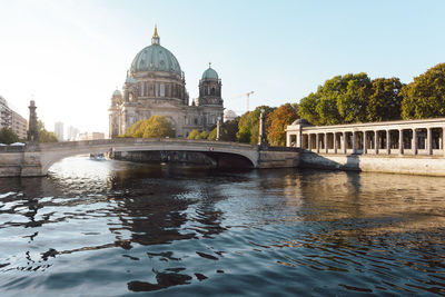 Arch bridge over river against buildings