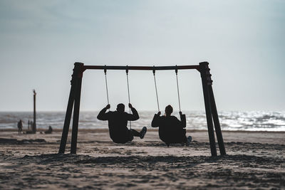 Couple swing on beach at northsea