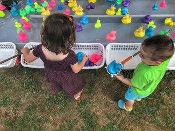 High angle view of siblings playing with rubber ducks