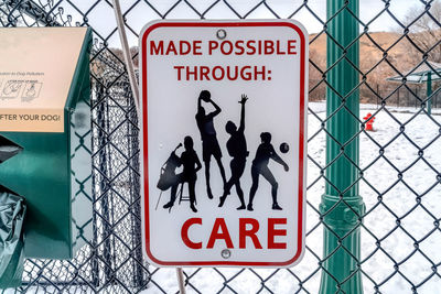 Close-up of warning sign on fence