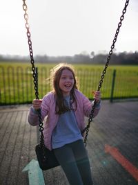 Smiling girl on swing at playground