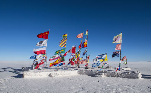 International flags planted on the salt flats of uyuni in bolivia