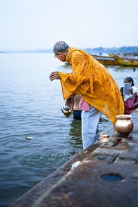 Side view of man in river against sky