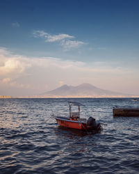 Boat in sea against sky during sunset